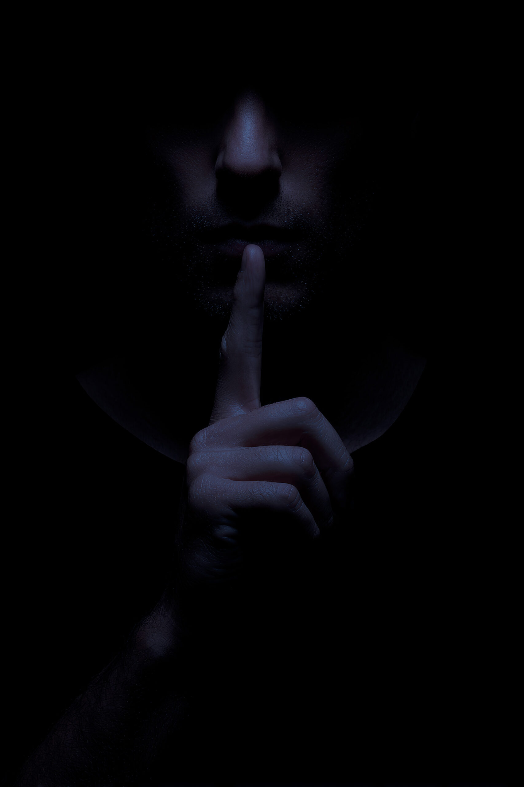A mysterious man appears in darkness, with a finger on his lips, symbolizing silence and secrecy. The shadows create a dramatic and intriguing atmosphere.